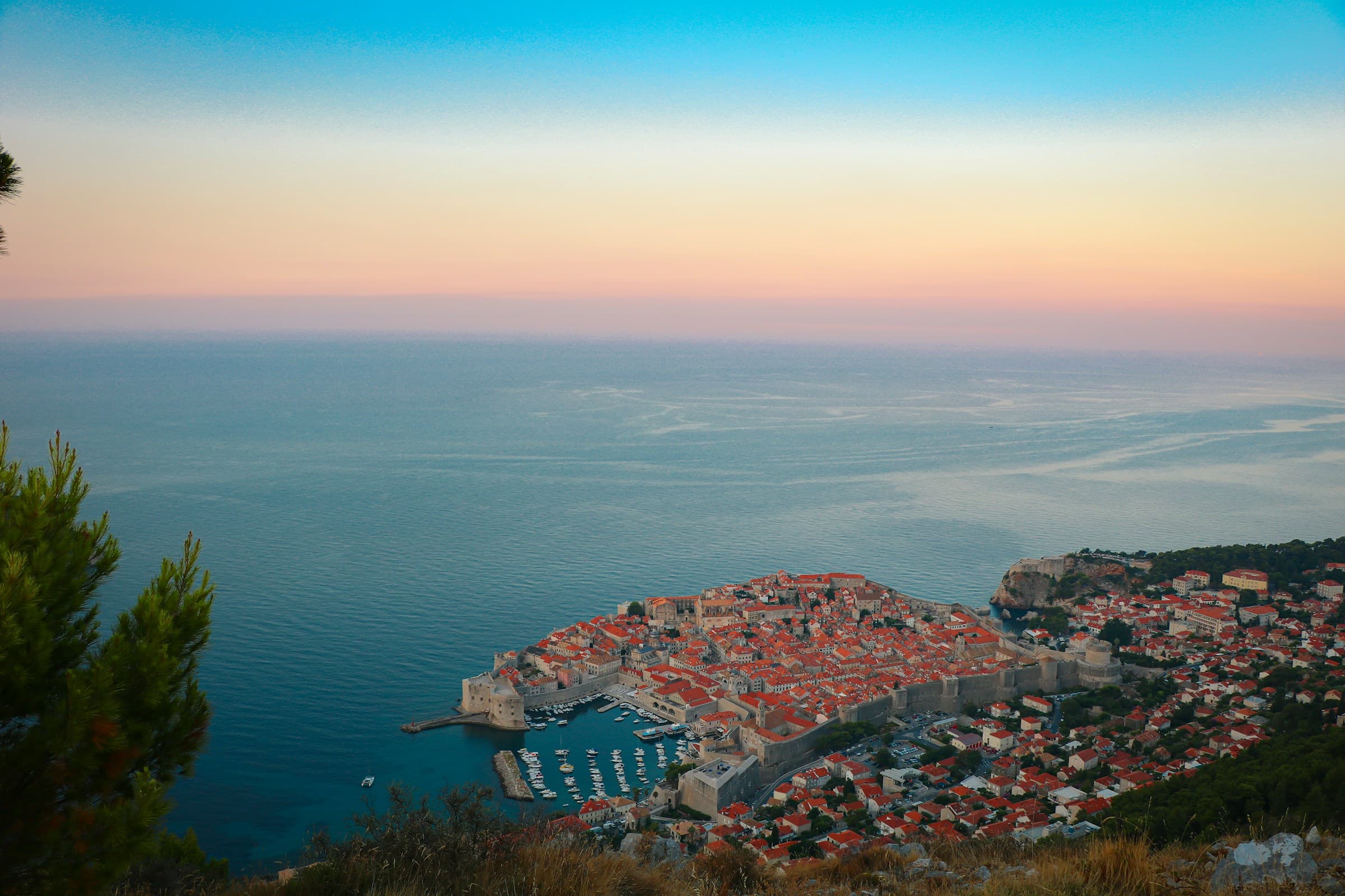 Sea kayaking along Dubrovnik city walls at sunset