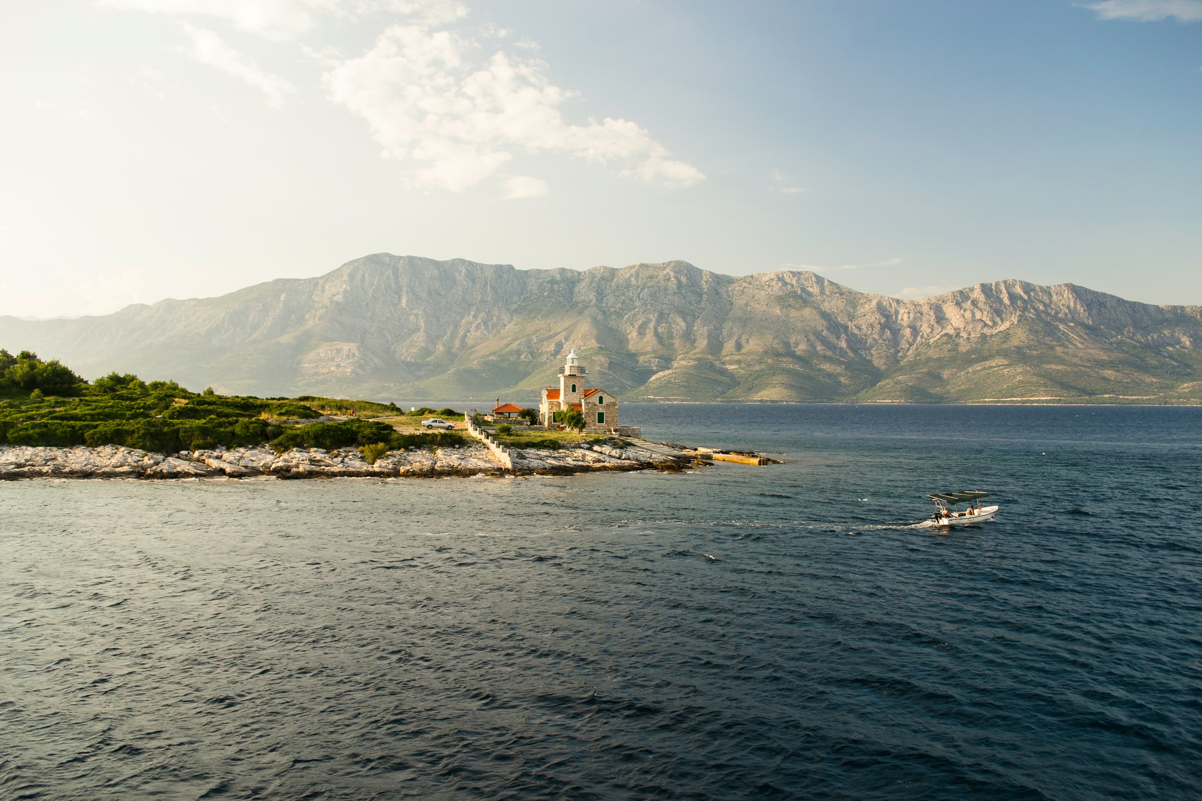 Calm shoulder-season Adriatic light around a stone lighthouse on the Croatian coast.