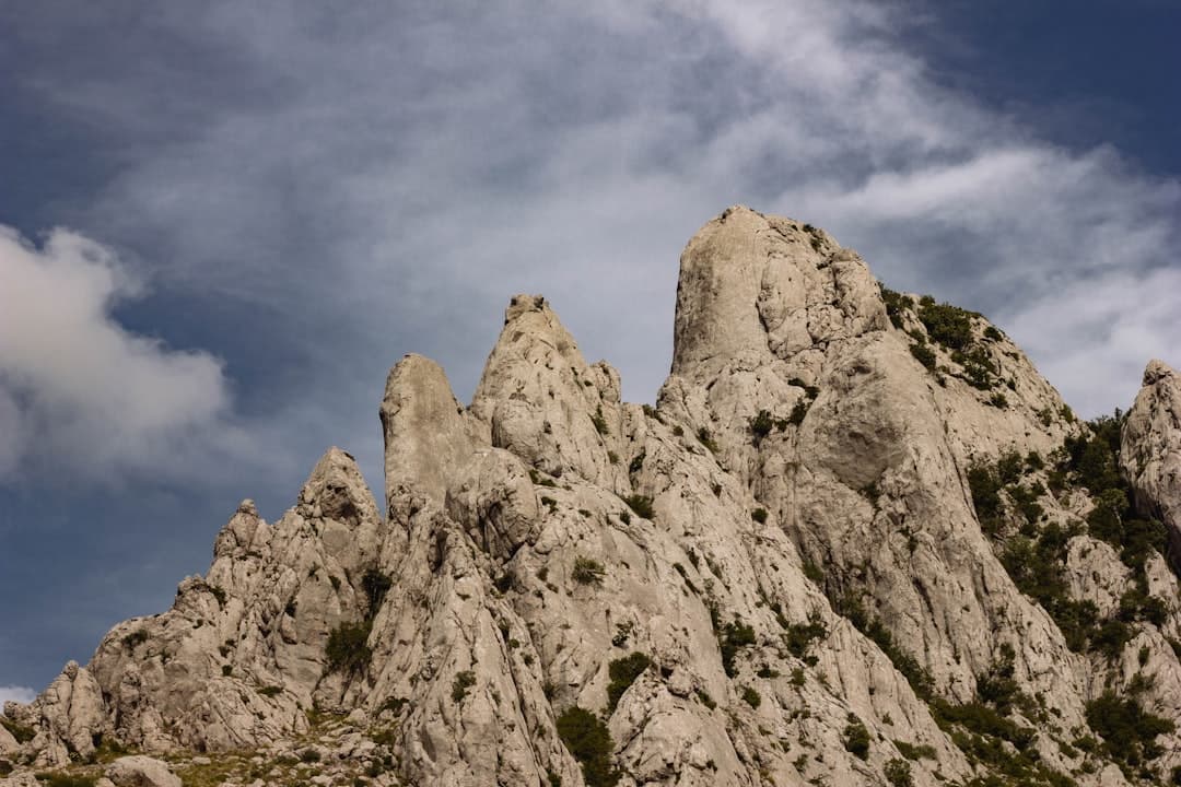 Vertical limestone spires rising above scrubland on the Velebit — the rock type that draws climbers to Anića Kuk and the Paklenica walls.