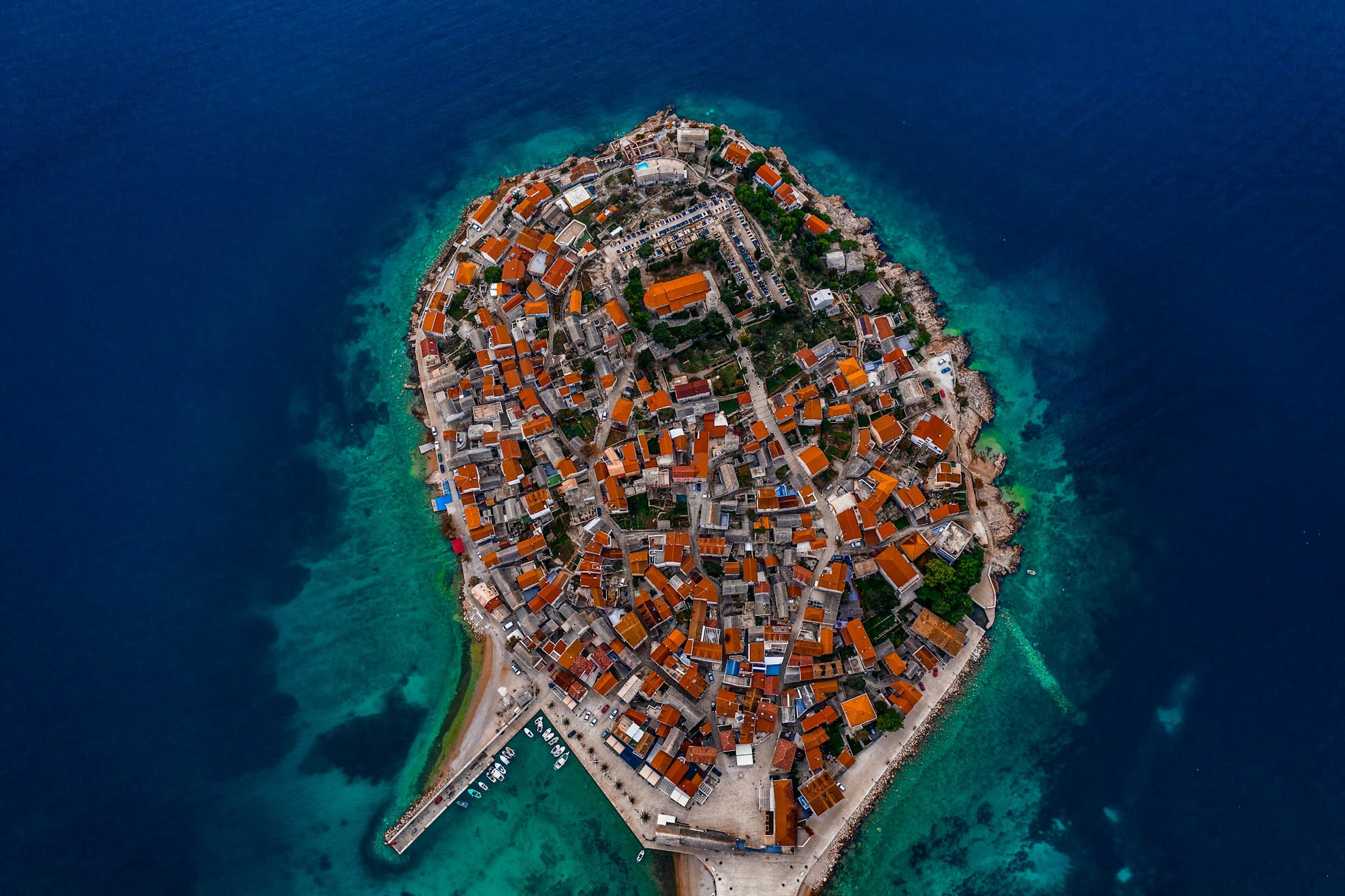 Primošten peninsula with stone houses and hilltop church surrounded by turquoise sea