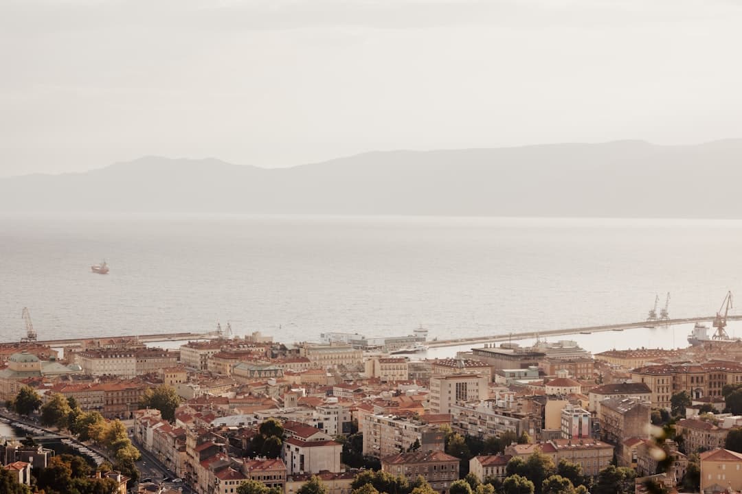 Rooftops of Rijeka stepping down towards the Kvarner Bay with the mountains of Krk in the distance — the city that hosts the carnival.