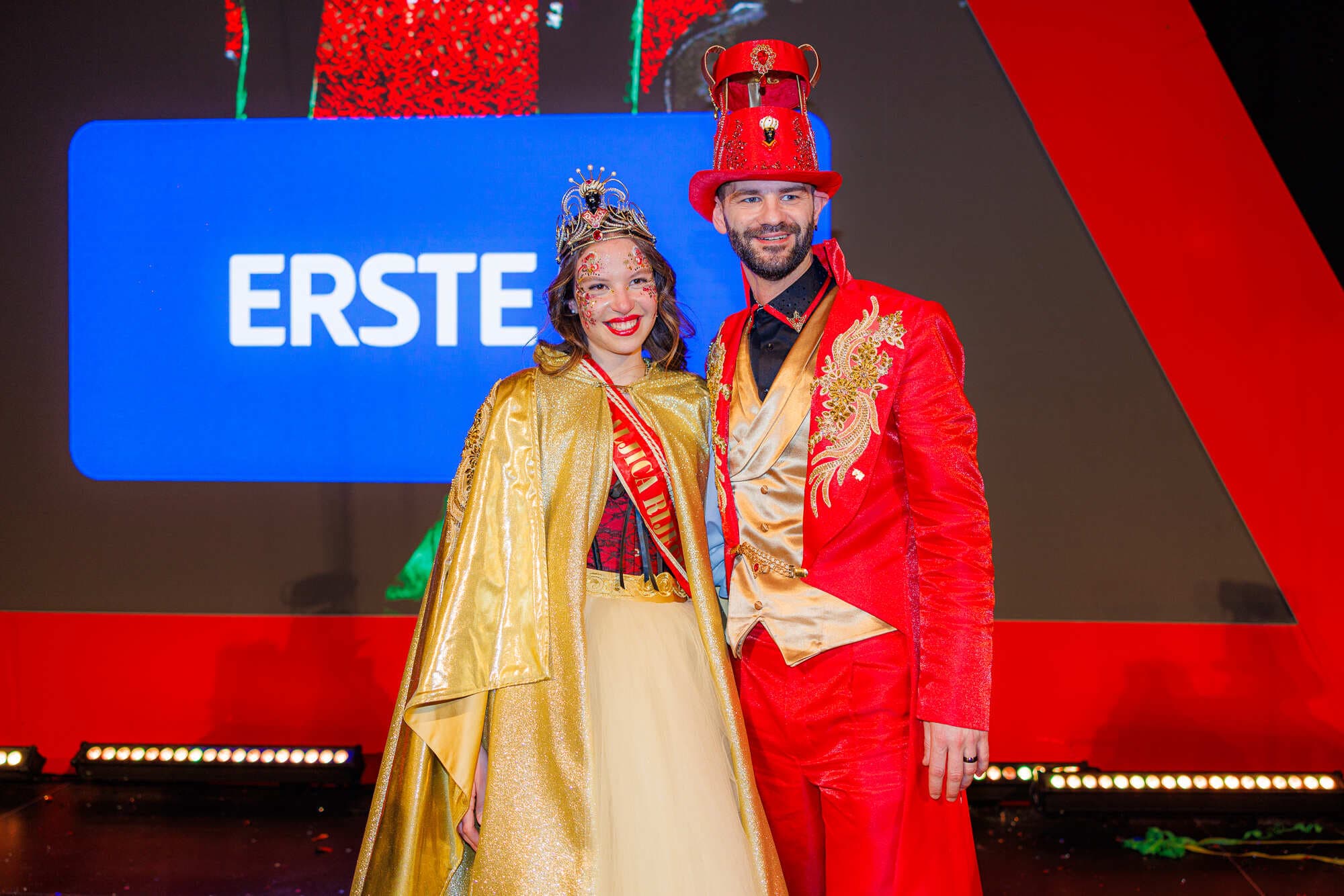 La Regina del Carnevale di Rijeka in mantello e corona d'oro accanto al Maestro del Carnevale in abito rosso e oro sul palco dell'Elezione della Regina.