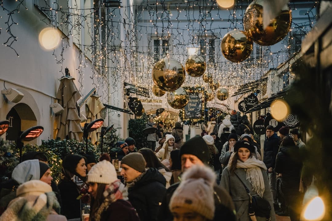 Besucher schlendern durch den Advent in Zagreb unter Baldachinen aus riesigen goldenen Kugeln und Lichterketten.