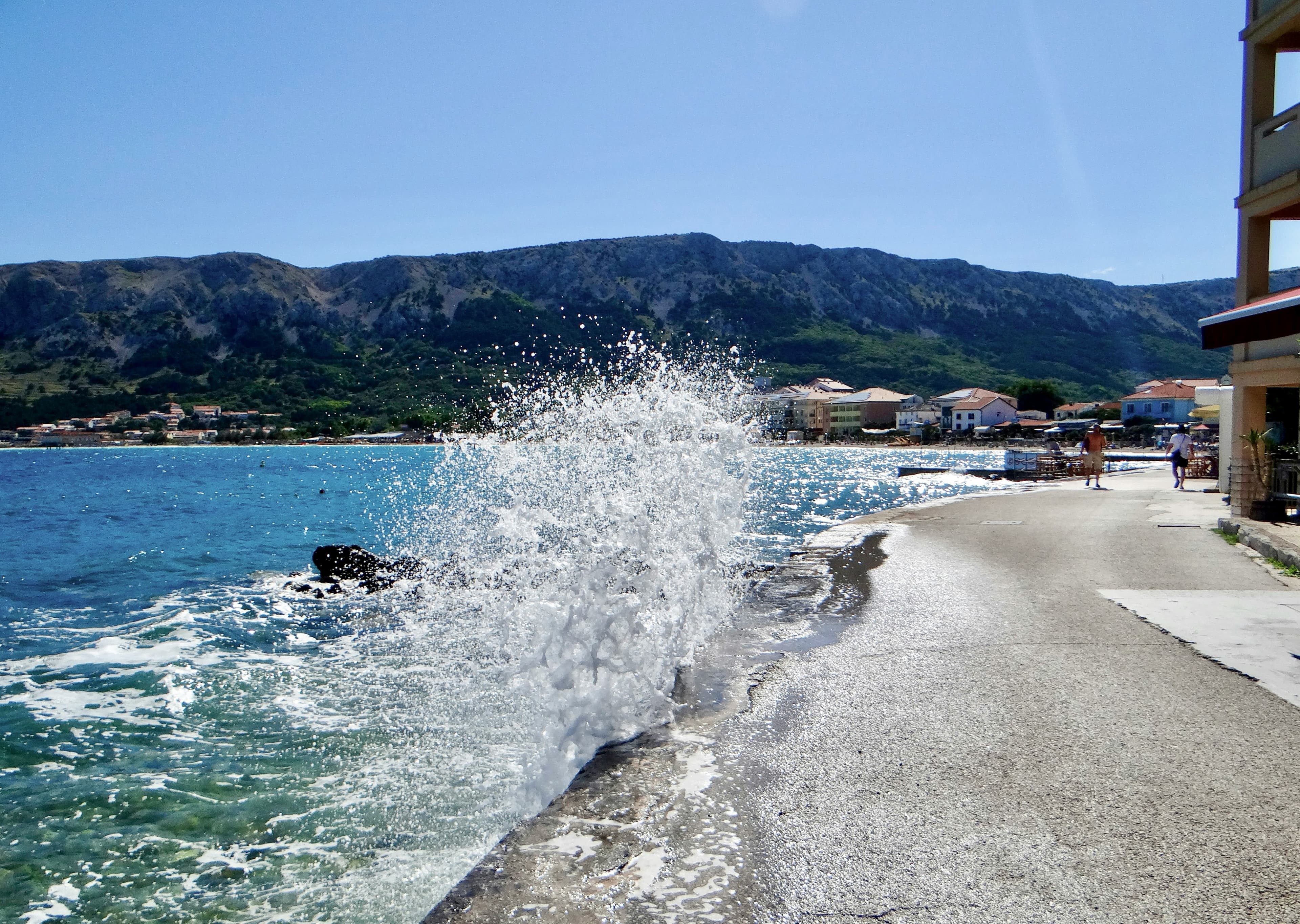 Baška riva seafront with boats and the Velebit mountains in the background