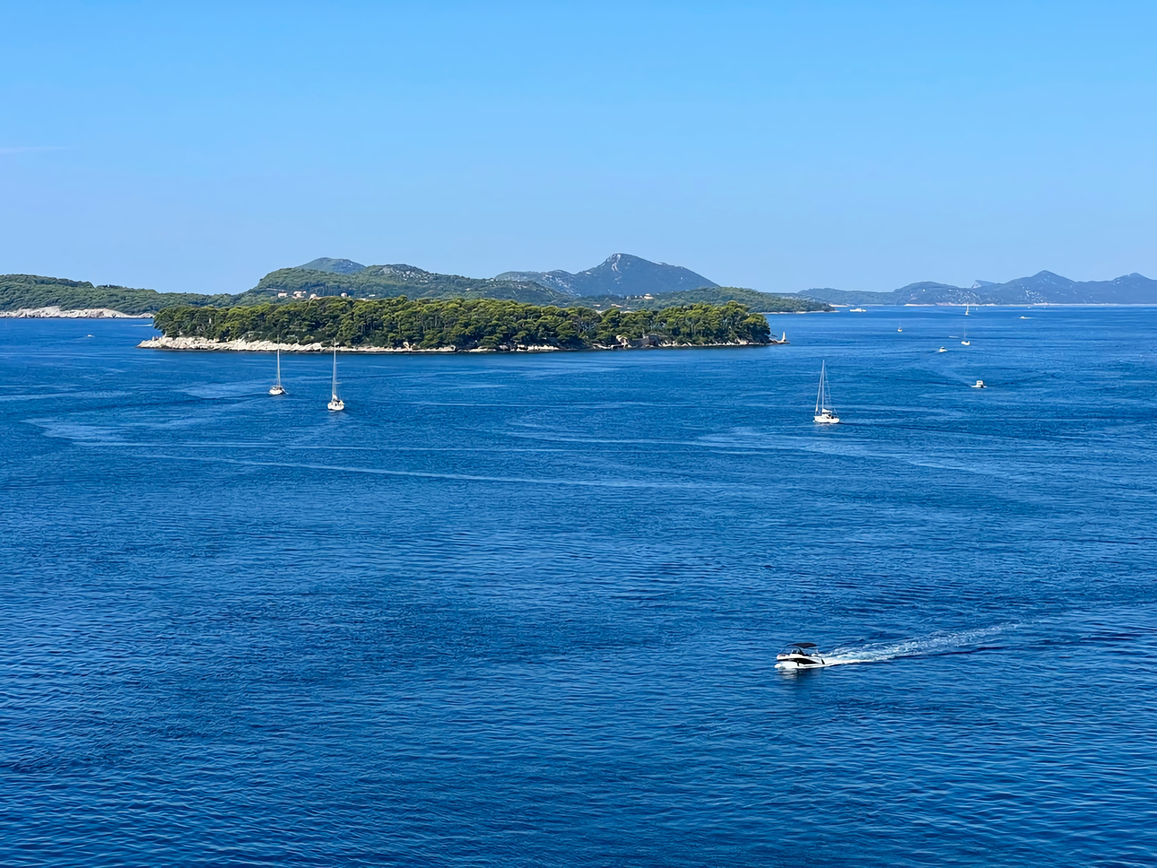 Sailing boat on the open sea near Lokrum island with Dubrovnik in the distance