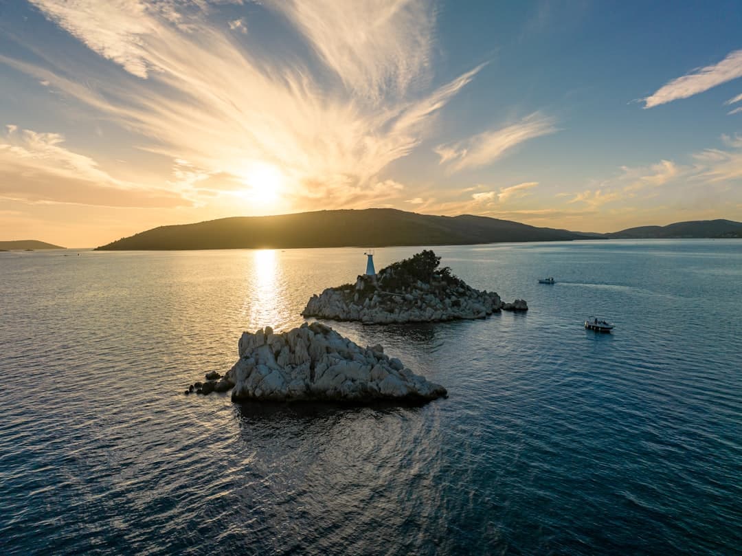 Sunset over a small island in the Adriatic — the post-paddle window when the maestral has dropped and the sea flattens.