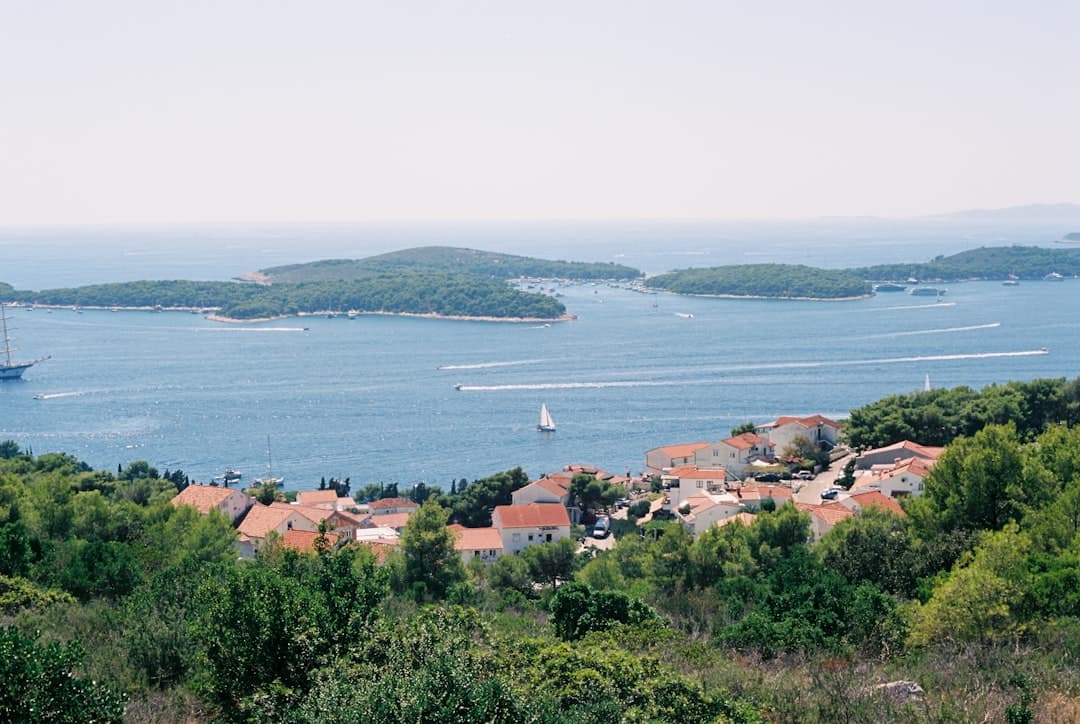 Looking across a calm Dalmatian bay with boats moored offshore — the kind of sheltered anchorage that makes Telašćica a sailing favourite.