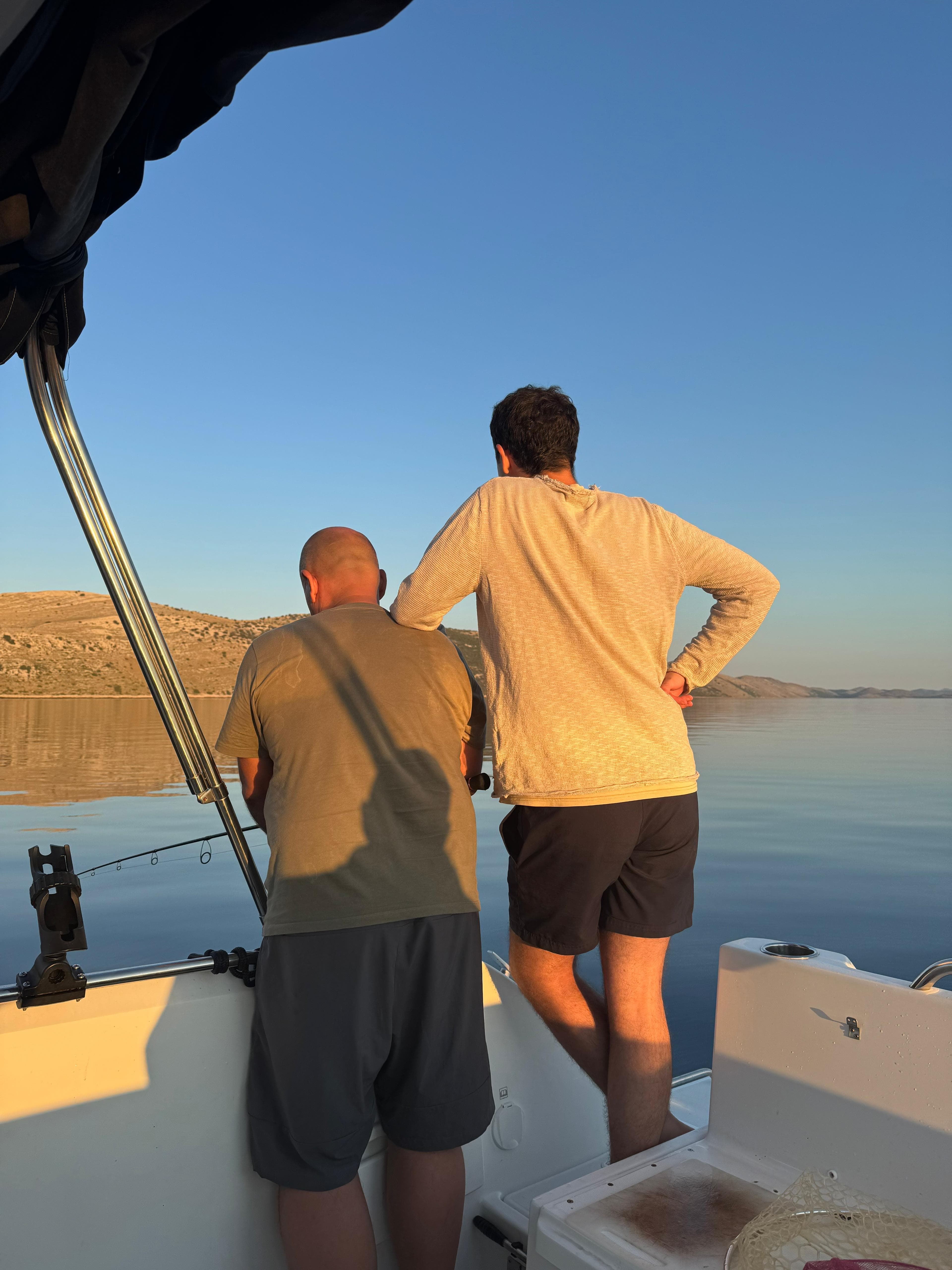 Family on a small boat fishing on the calm Adriatic near Croatian islands