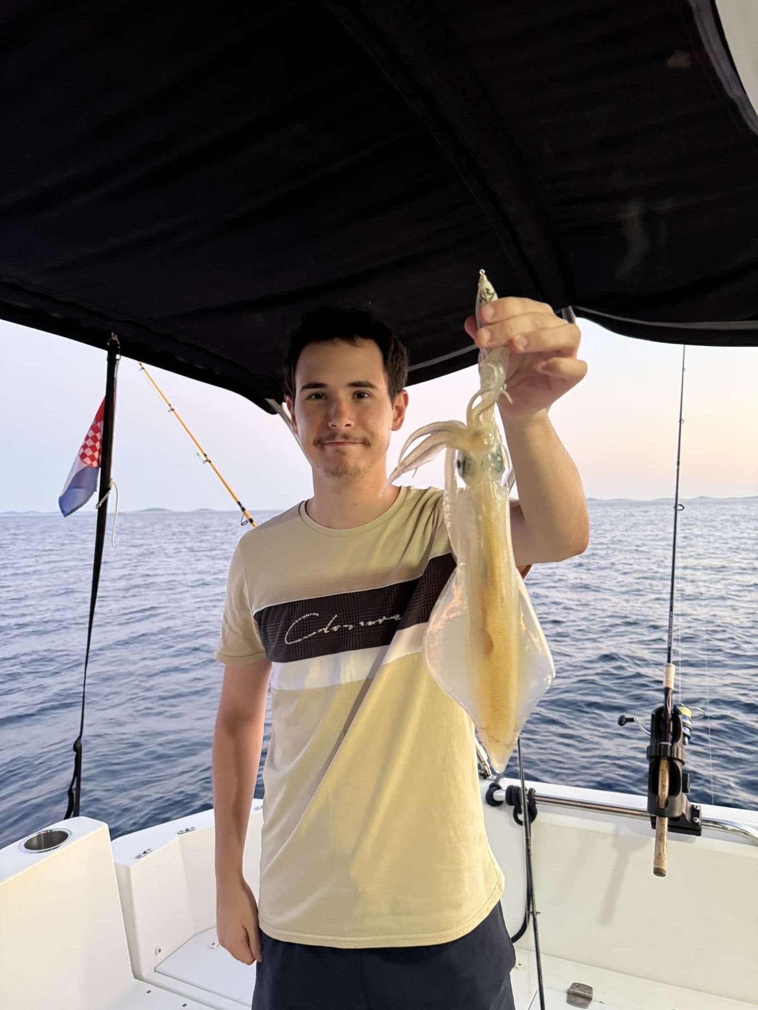 Night squid fishing from a small boat on the Adriatic — underwater lamp attracting squid to the surface